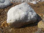 A salt covered rock on the shore of the Dead Sea
