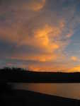 The sun lighting up the clouds at dusk over Shoshone Lake in Yellowstone National Park