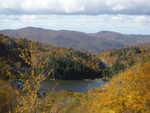 A small lake surrounded by trees changing color